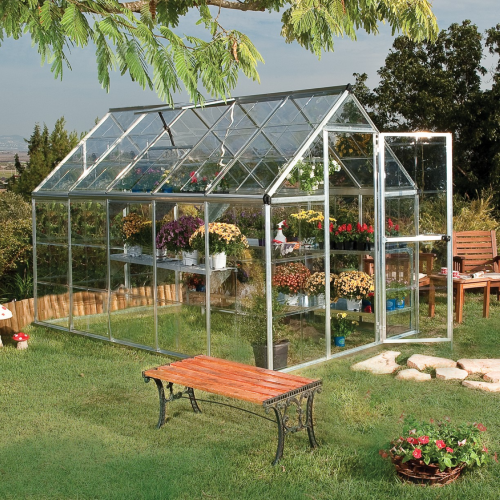 Side view of the greenhouse in a backyard setting, highlighting the built-in gutter system.