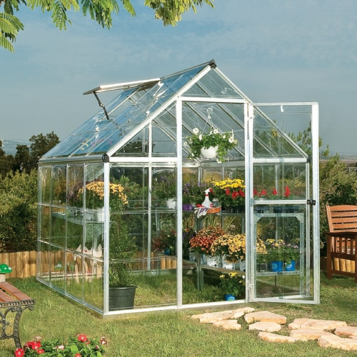 Side view of the greenhouse in a backyard, highlighting the built-in gutter system.