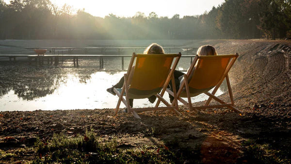 Two people enjoying the sunset in beach chairs