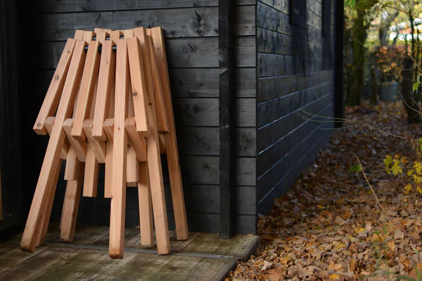 Closed Weltevree Fieldchairs leaning against a wall, highlighting their compact storage.